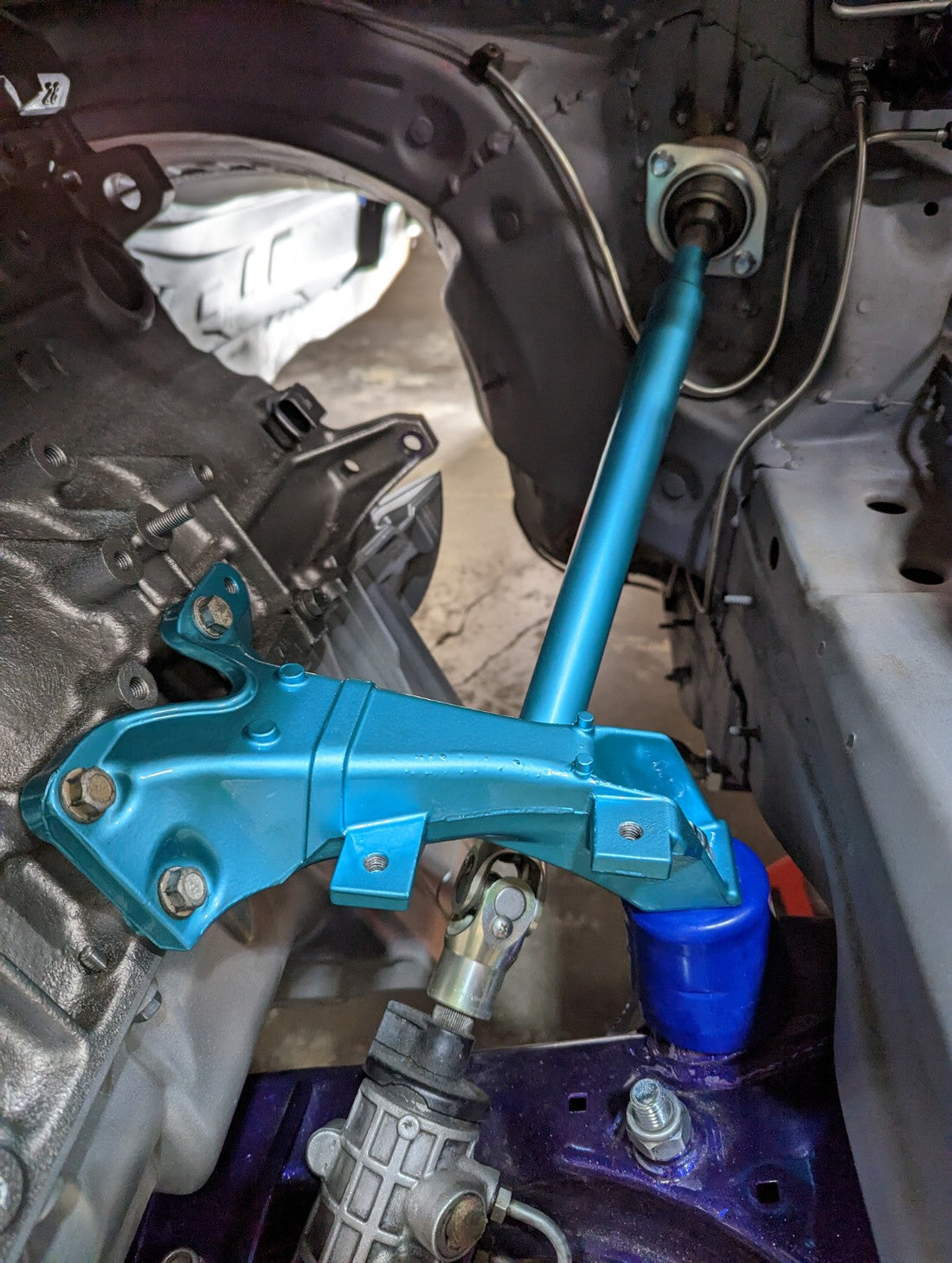 Custom steering-shaft support and universal-joint assembly installed in a race car