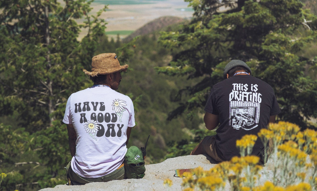 Motorsport crew members studying mountain terrain from a safe overlook