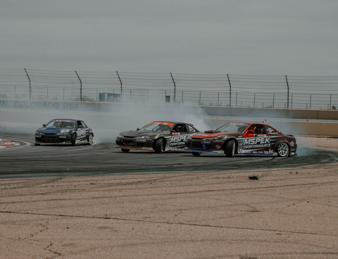 Representative drifting photo of three drift cars in tandem on track; not a Formula DRIFT 2026 technical inspection image. Photo by Jacob Moore via Pexels.