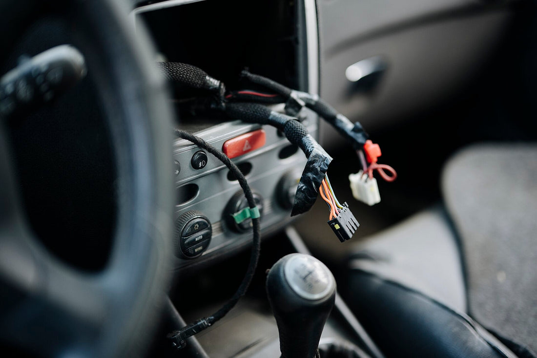 Representative vehicle wiring and controls during service; not a Race Club harness or certification example. Photo by Shixart1985 / Wikimedia Commons, CC BY 2.0.