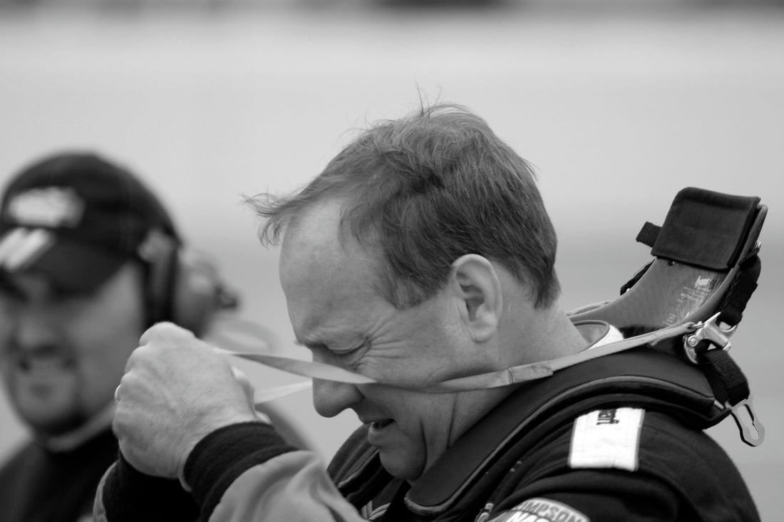 Ken Schrader removing a HANS device after practice at Texas Motor Speedway in 2007; representative frontal-head-restraint photograph. Photo by Bo Nash / Wikimedia Commons, CC BY-SA 2.0.