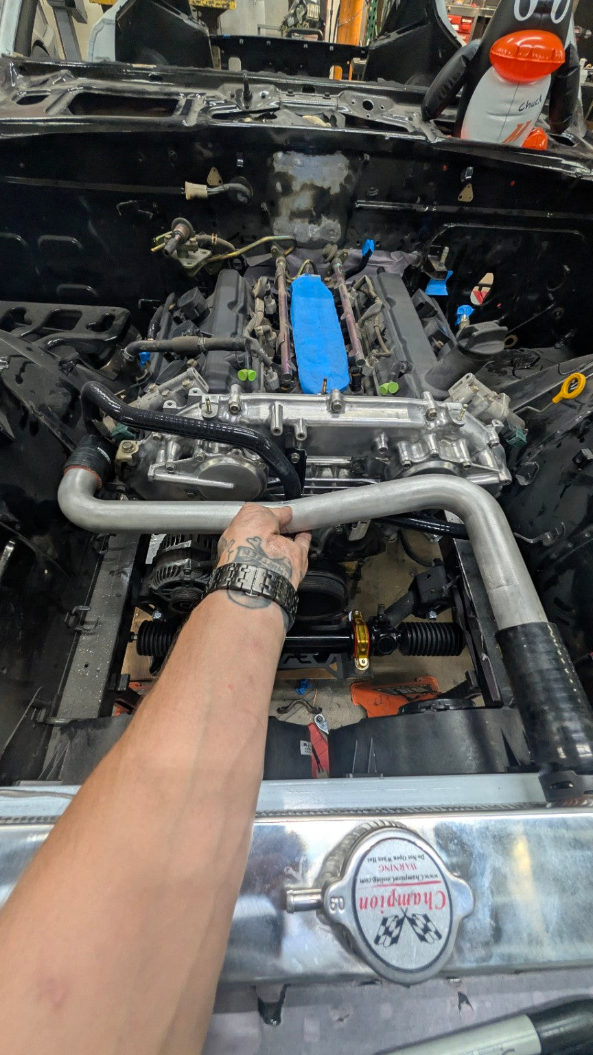 A formed coolant tube held above the VQ35DE in an earlier Race Club 280Z engine-bay mock-up