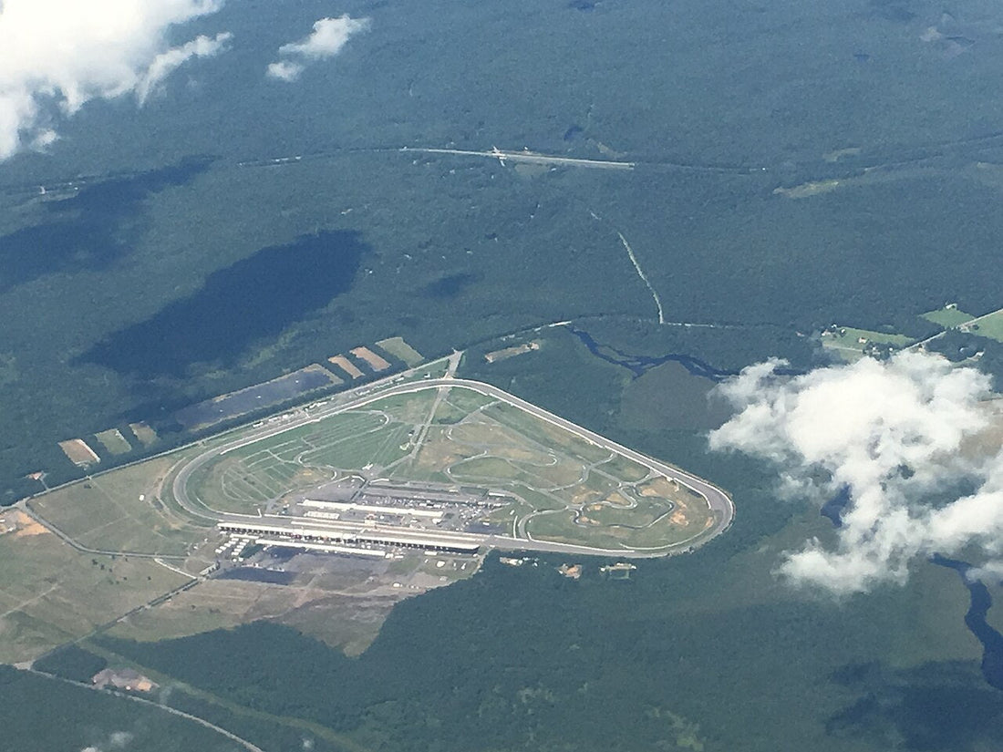 Aerial photograph of Pocono Raceway showing the oval, infield roads and surrounding forest.