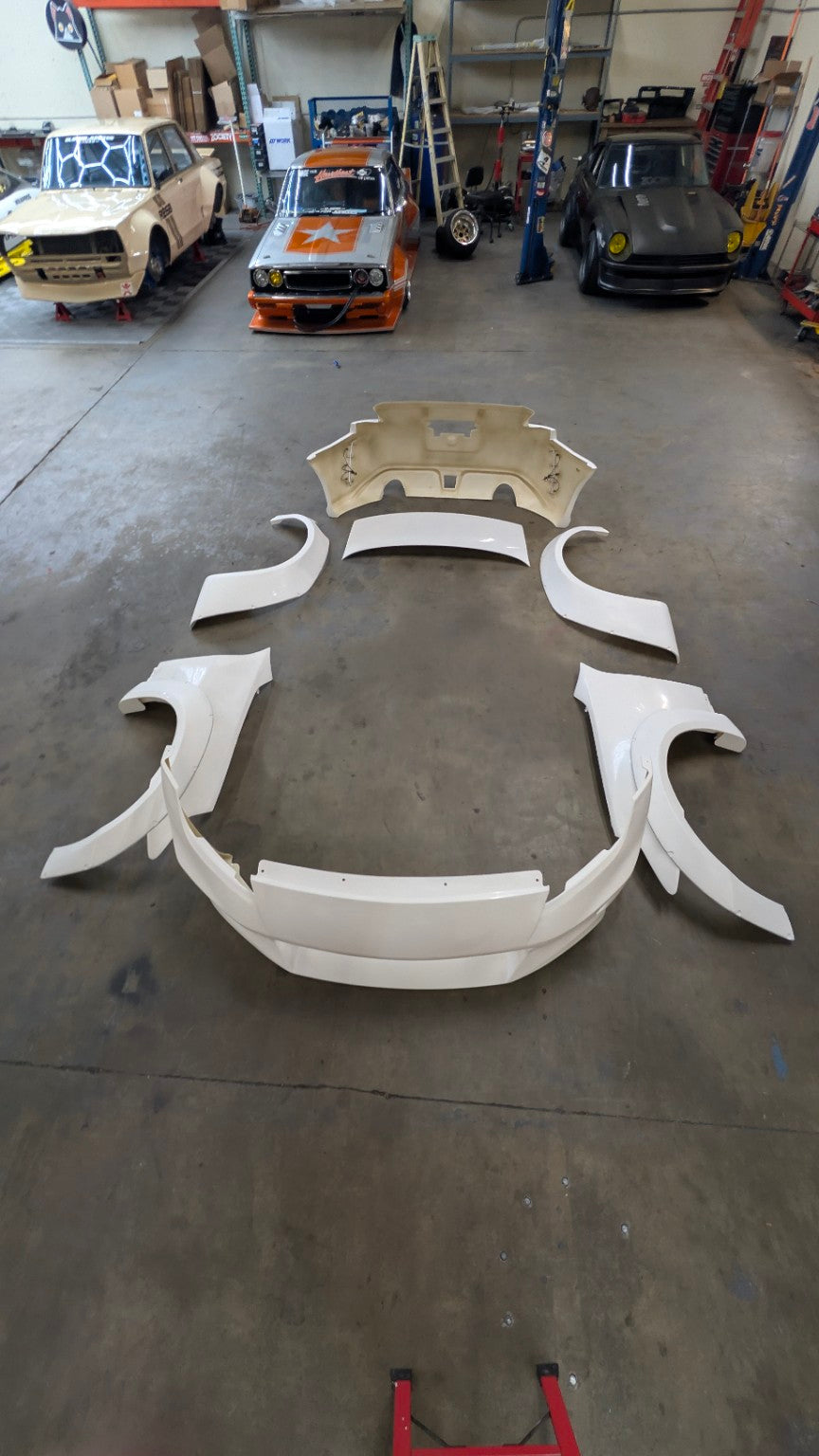 Complete white Liberty Walk Nissan 350Z body kit laid out before final paint preparation
