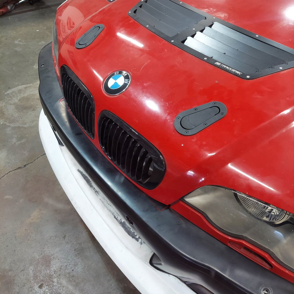 Race Club BMW E46 hood pin mounting kit installed with optional AeroCatch latches