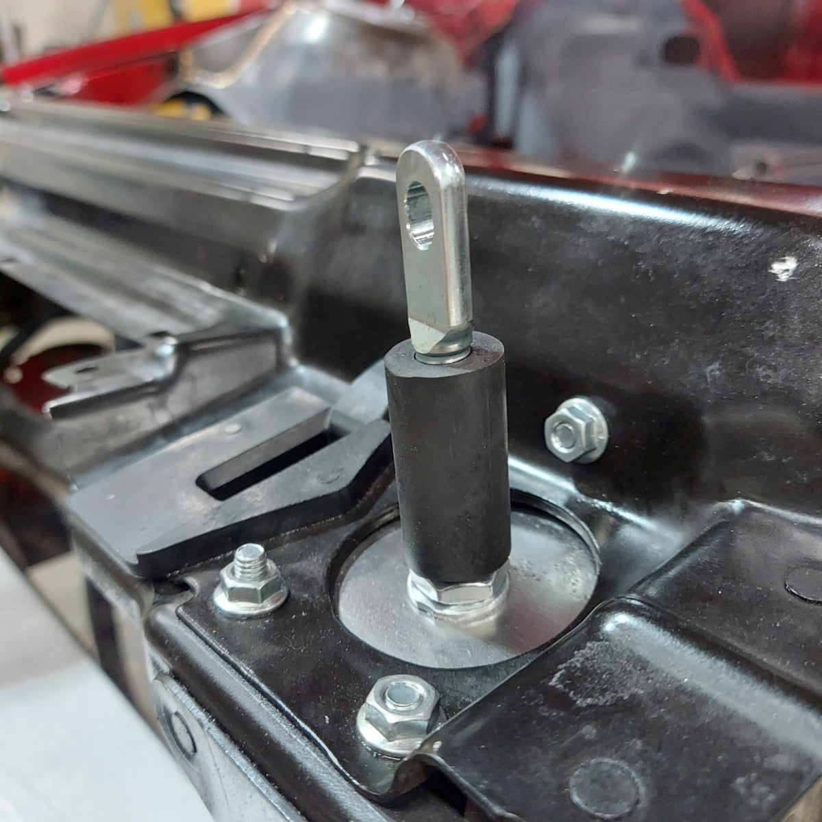 Race Club E46 hood pin mounting bracket and stud installed on front structure