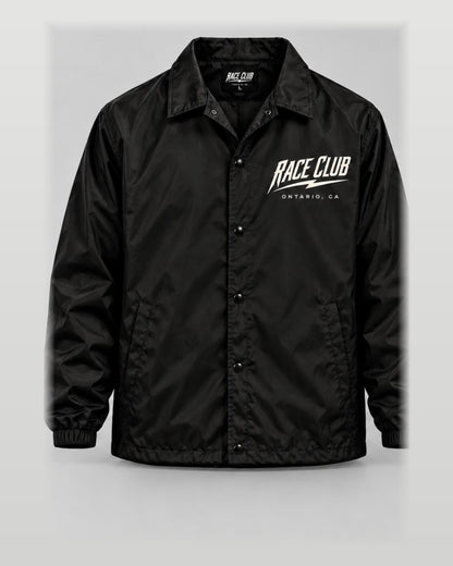 Front view of black Race Club snap-front coach jacket with left chest branding